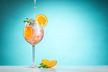 Image showing The rose exotic cocktail and fruit on blue