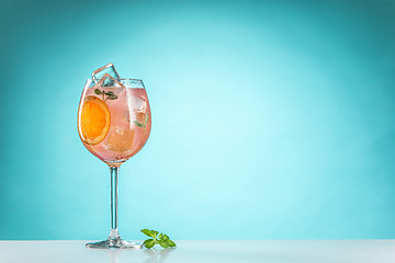 Image showing The rose exotic cocktail and fruit on blue