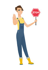 Image showing Caucasian farmer holding stop road sign.