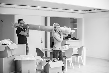 Image showing couple carrying a carpet moving in to new home