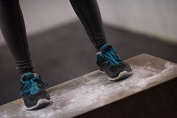 Image showing black woman is performing box jumps at gym