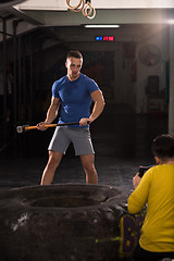 Image showing man workout with hammer and tractor tire