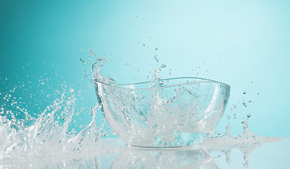 Image showing The water splashing to glass bowl on white background