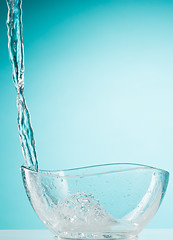 Image showing The water splashing to glass bowl on white background