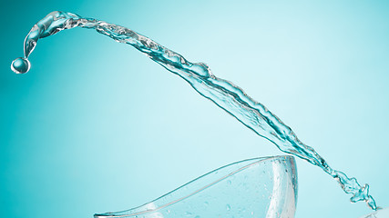 Image showing The water splashing to glass bowl on white background