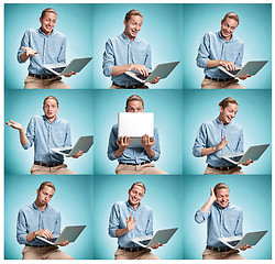 Image showing The smiling young man in a blue shirt working on laptop