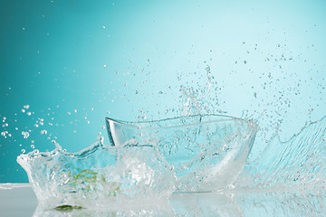 Image showing The water splashing to glass bowl on white background