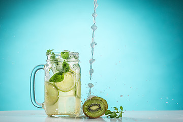 Image showing The rose exotic cocktail and fruit on blue