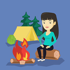 Image showing Woman sitting on log near campfire in the camping.