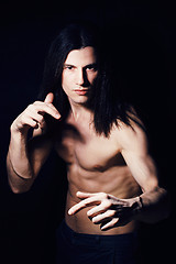 Image showing handsome young man with long hair naked torso on black backgroun