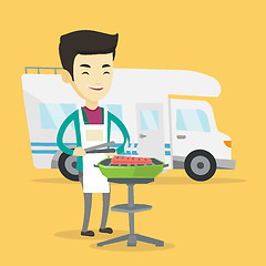 Image showing Man having barbecue in front of camper van.