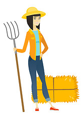 Image showing Young asian farmer holding a pitchfork.