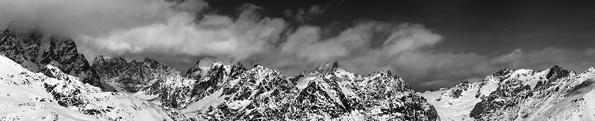 Image showing Black and white large panoramic view on snow mountains in haze a