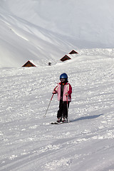 Image showing Little skier on ski slope at sun winter day