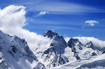 Image showing Winter mountains with snow cornice and blue sky with clouds in n