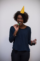 Image showing black woman in party hat blowing in whistle