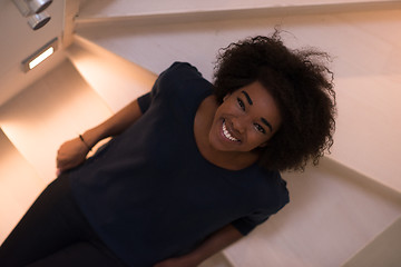 Image showing black woman sitting on stairs at home