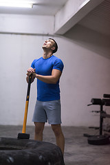 Image showing man workout with hammer and tractor tire