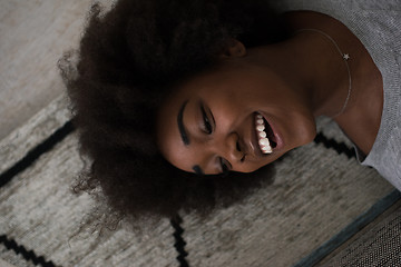 Image showing black woman lying on carpet