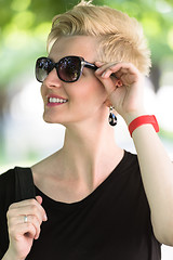 Image showing young woman with short blond hair and sunglasses