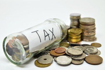 Image showing Tax lable in a glass jar with coins spilling out