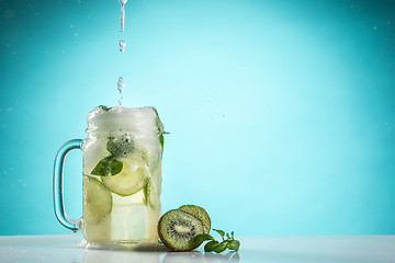 Image showing The rose exotic cocktail and fruit on blue