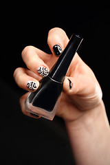 Image showing Crazy manicure, black and white grid Woman's hand with fingernails painted in black and white checkered 