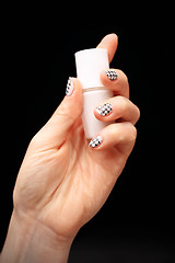 Image showing Crazy manicure, black and white grid Woman's hand with fingernails painted in black and white checkered 