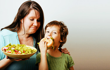 Image showing mature woman holding salad and little cute boy with hamburger te