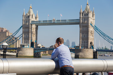 Image showing British businessman talking on mobile phone outdoor in London city, UK.