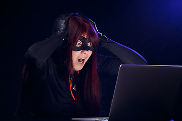 Image showing Surprised hacker next to laptop