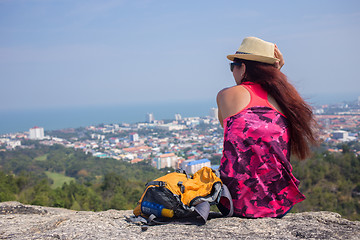 Image showing Brunette sits on hill