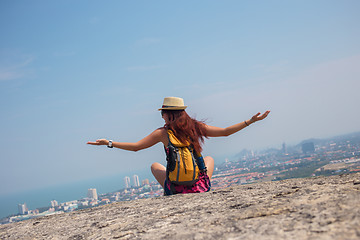 Image showing Brunette sits back on hill