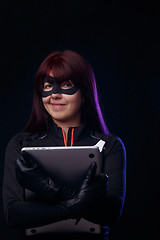 Image showing Brunette thief holds stolen laptop