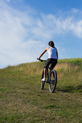 Image showing Sport bike woman on the meadow with a beautiful landscape