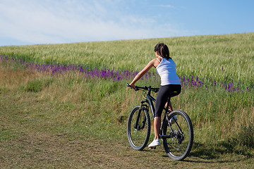 Image showing Sport bike woman on the meadow with a beautiful landscape