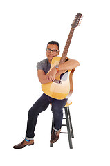 Image showing Hispanic mal sitting with his guitar.