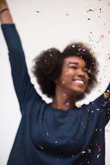 Image showing African American woman blowing confetti in the air
