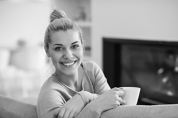 Image showing woman with a mug near a fireplace