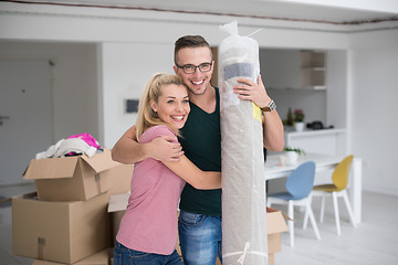 Image showing couple carrying a carpet moving in to new home