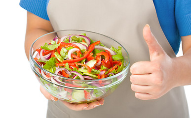 Image showing Cook is holding a big bowl with fresh salad