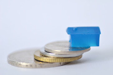 Image showing Little plastic house on metal coins