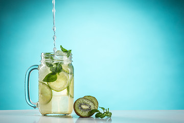 Image showing The rose exotic cocktail and fruit on blue