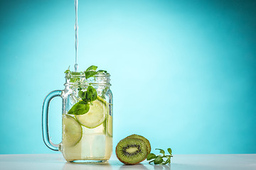 Image showing The rose exotic cocktail and fruit on blue