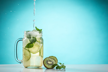 Image showing The rose exotic cocktail and fruit on blue