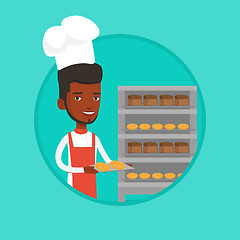 Image showing Happy young male baker holding tray of bread.