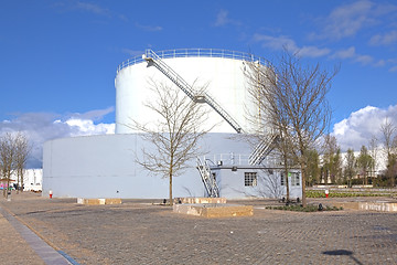Image showing White tanks in tank farm with iron staircase 