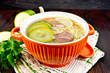 Image showing Soup with zucchini and noodles in red bowl on kitchen towel