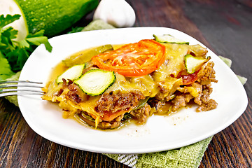 Image showing Casserole from minced meat and zucchini in plate on dark board