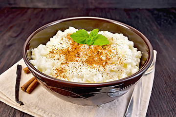 Image showing Rice porridge with cinnamon in bowl on napkin